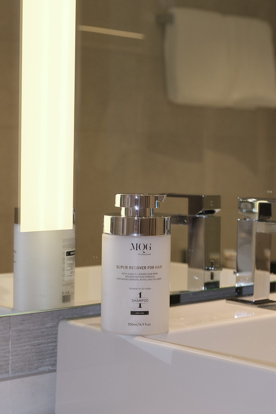 Dầu gội MQG Nhật Tâm đặt trên lavabo salon