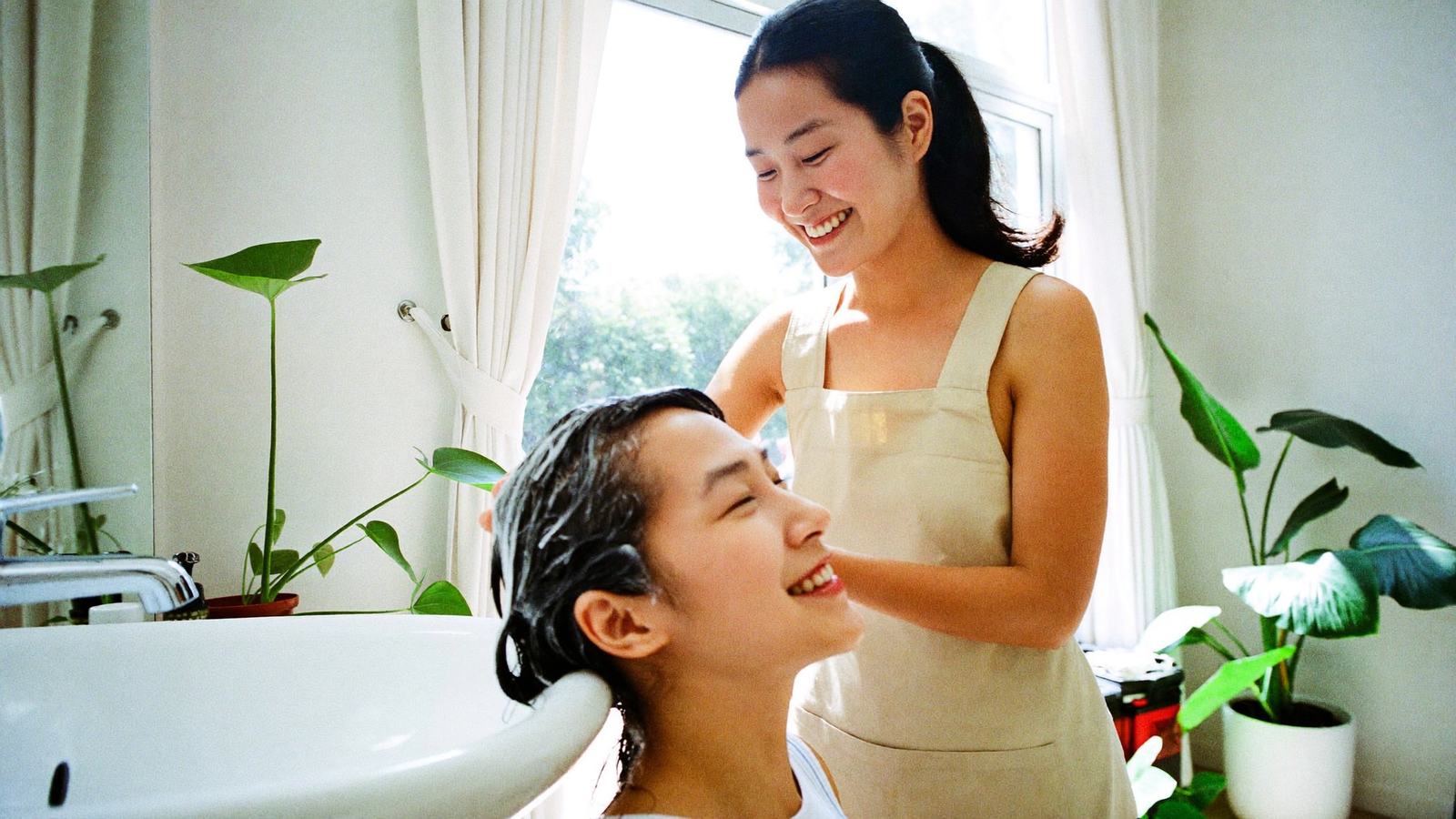 Thợ gội đầu trẻ trung massage cho khách tại salon tóc sáng đẹp