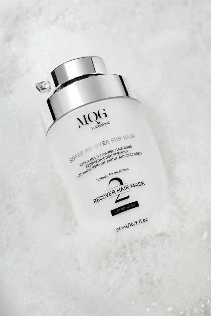 Hũ hấp ủ tóc MQG Professional số 2 Recover Hair Mask đặt trên nền bọt trắng