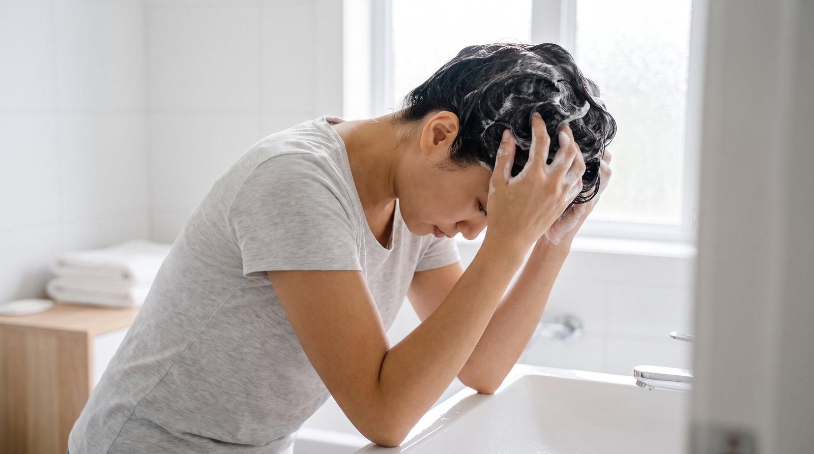 Cô gái gội đầu massage bọt dầu gội vào chân tóc để xử lý tóc dầu bết
